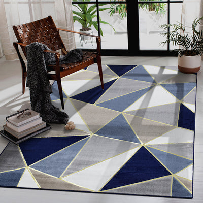 Modern geometric carpet in blue and gray hues, perfectly styled with a wooden chair and decor.