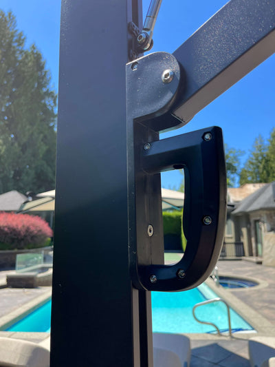 Close-up of RM Sun Umbrella's handle mechanism next to a pool, showcasing its durable design and easy adjustability.