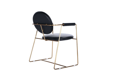 Mera chair with a gold bent metal frame and black leather upholstery, perfect for dining room elegance.