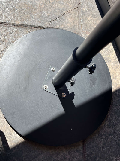 Base for RM sun Unbrella with a sturdy black round design, ensuring stability for outdoor use.