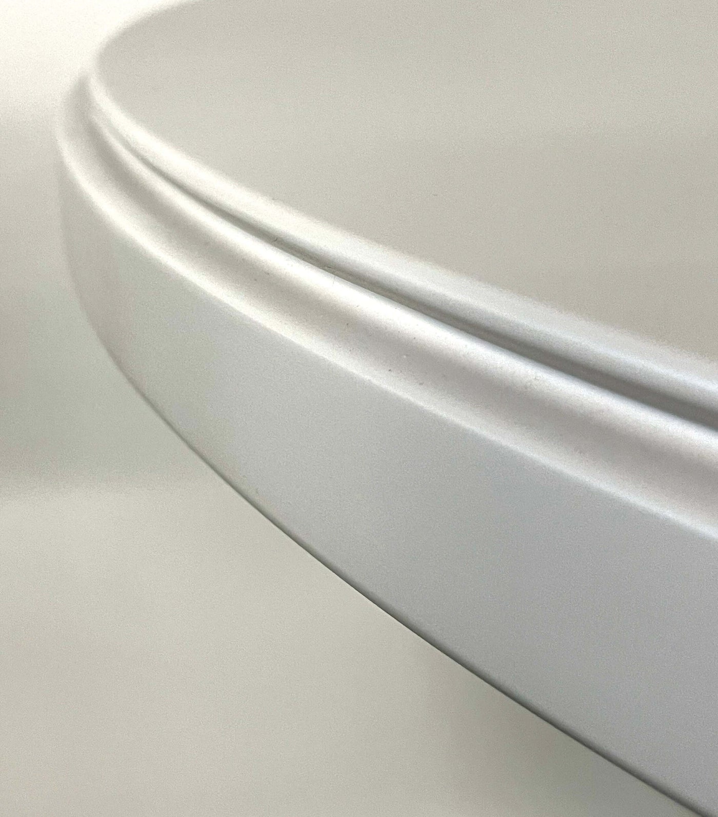 Close-up of a retro coffee shop table edge with a smooth lacquer finish in white.